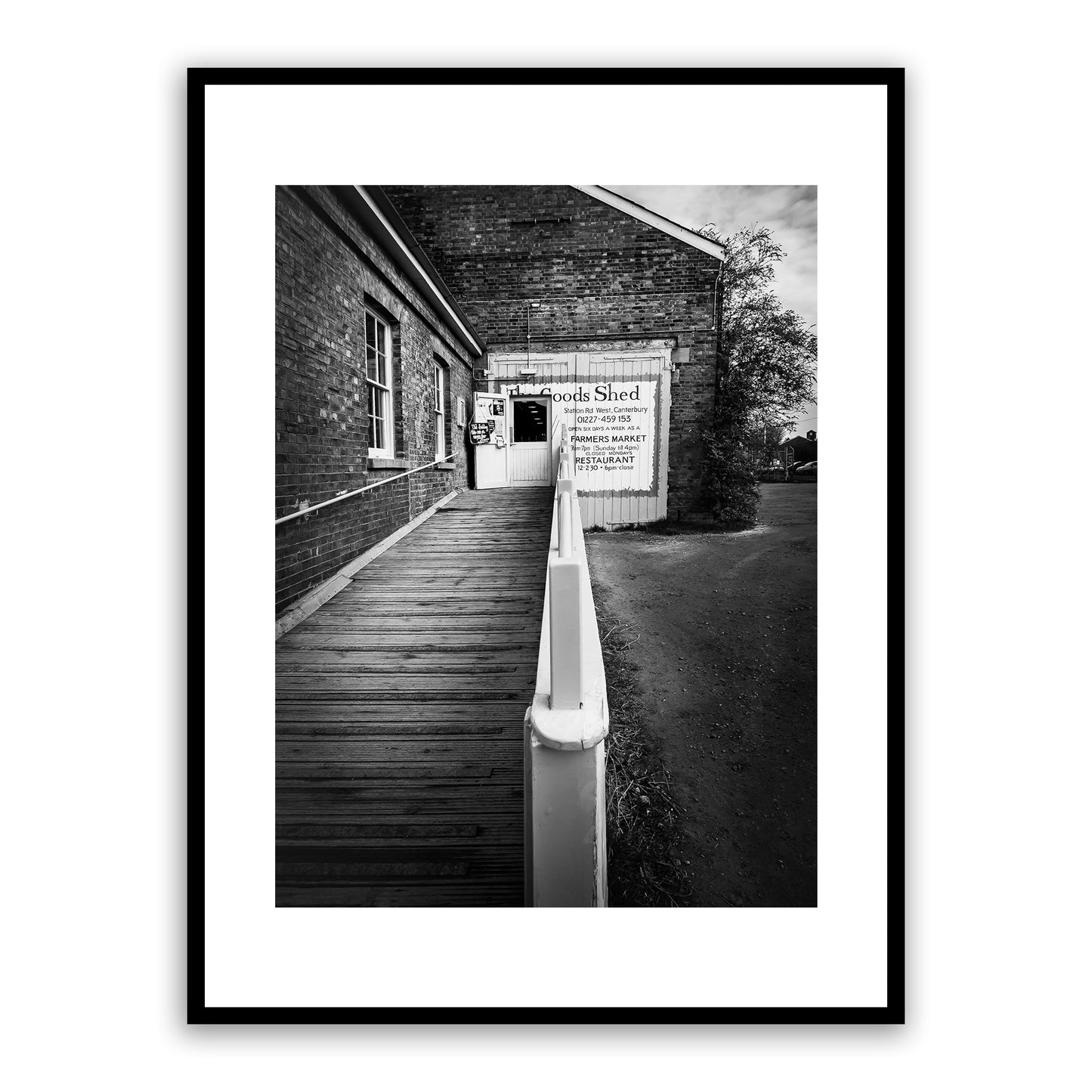 The Goods Shed, Station Road West, Canterbury, Kent, England. Independent farmers’ market and food hall in an 18th century early Victorian locomotive shed. A bustling vibrant market and restaurant with a range of food stalls selling mouthwatering local and international produce. Fine art black and white photography print for sale.