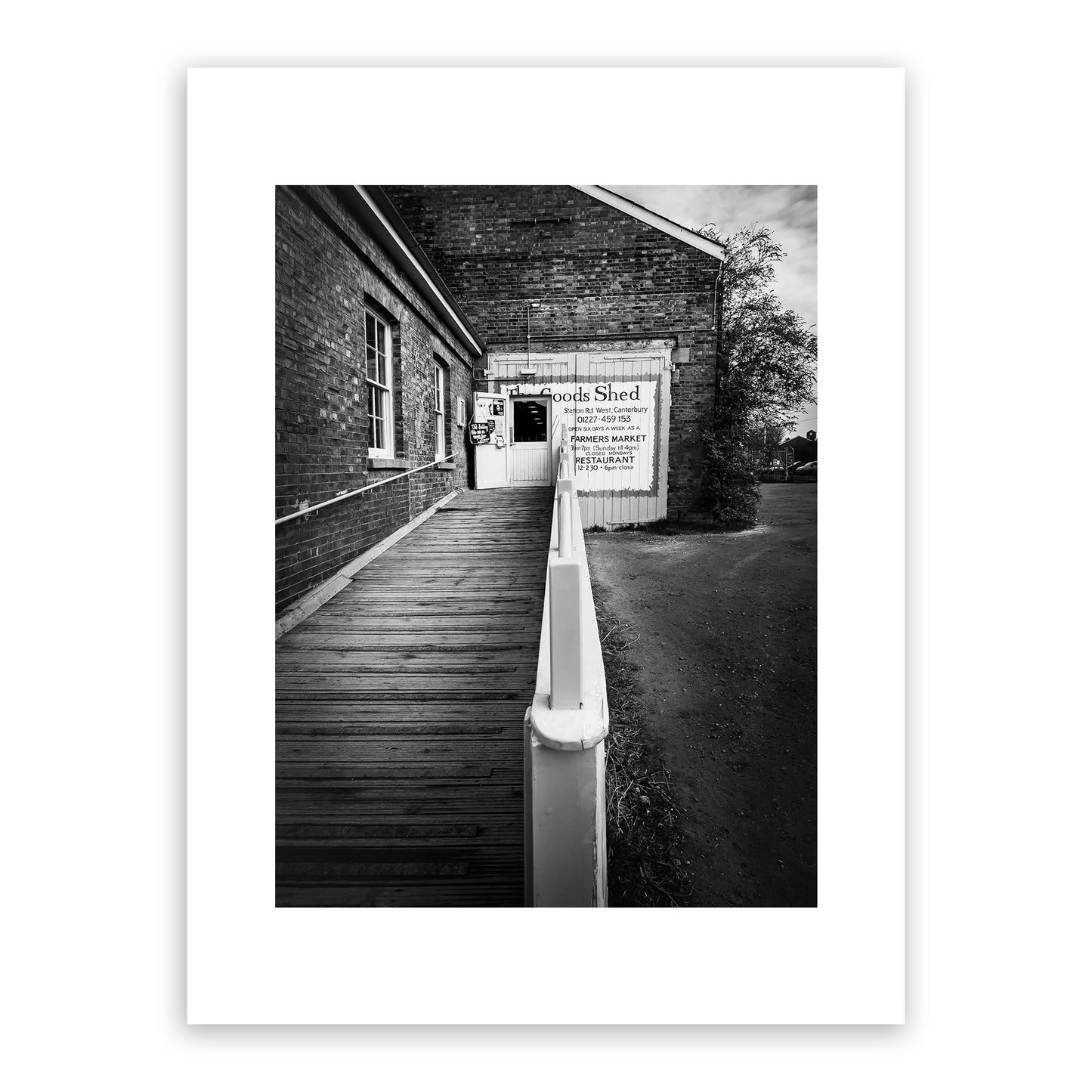 The Goods Shed, Station Road West, Canterbury, Kent, England. Independent farmers’ market and food hall in an 18th century early Victorian locomotive shed. A bustling vibrant market and restaurant with a range of food stalls selling mouthwatering local and international produce. Fine art black and white photography print for sale.