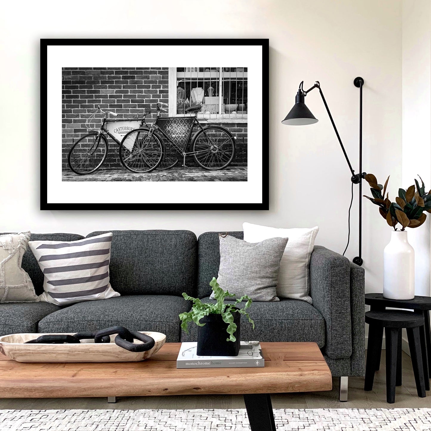 Old vintage bikes on the charming, cobbled, Water Lane, Canterbury, Kent, England, with signs for Canterbury Punting Company and The Mooring Café Bar. Rock, Paper, Scissors store visible through window. Fine art black and white photography print for sale.